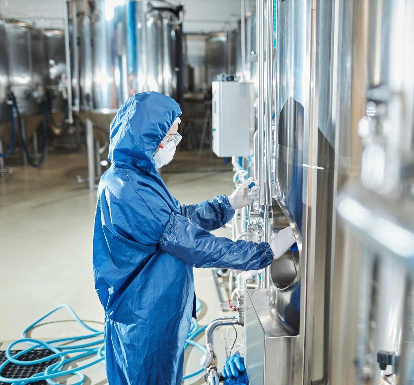 Woman wearing protective gear working at chemical factory
